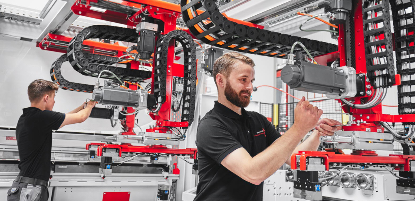 Zwei Techniker montieren CNC-Rohrbearbeitungsanlage von transfluid in Produktion.